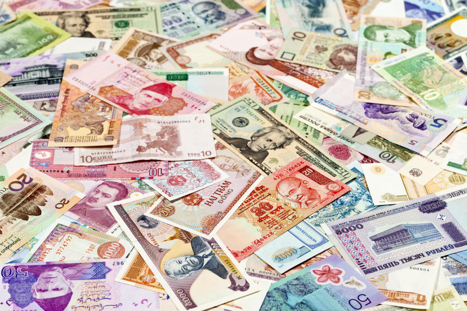 Bills of money from around the world, illustrating a story on Singapore private residential property transactions attributable to family offices.