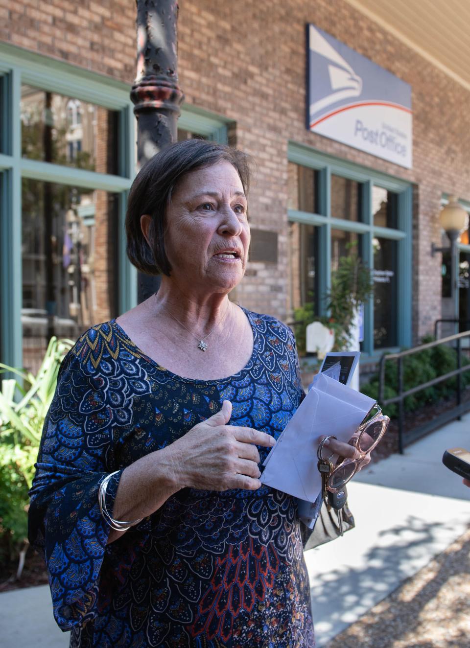 Kim Passwaters Baldwin, of Around Town Runners, talks about the Downtown Post Office on Palafox Place in Pensacola on Tuesday, Oct. 17, 2023. This location is scheduled to be closed.