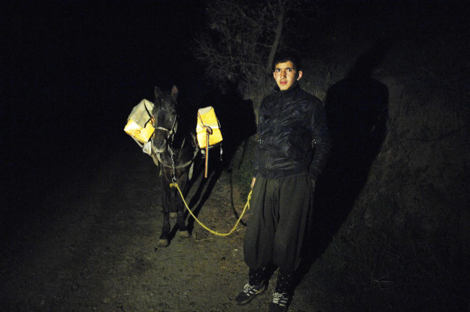 A smuggler holds the leash of a horse carrying alcoholic drinks during a smuggling operation to Iran at the border near Sulaimaniya, 260 km (162 miles) northeast of Baghdad March 20, 2010. Border security forces repeatedly clash with smugglers who use the dark and the rugged area to facilitate their operation. Picture taken on March 20, 2010. REUTERS/Jamal Penjweny