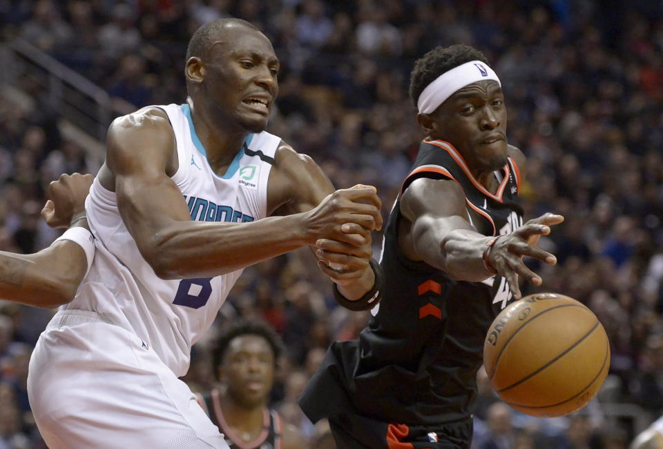 Charlotte Hornets center Bismack Biyombo (8) and Toronto Raptors forward Pascal Siakam (43) vie for control of the ball during second-half NBA basketball game action in Toronto, Friday, Feb. 28, 2020. (Nathan Denette/The Canadian Press via AP)