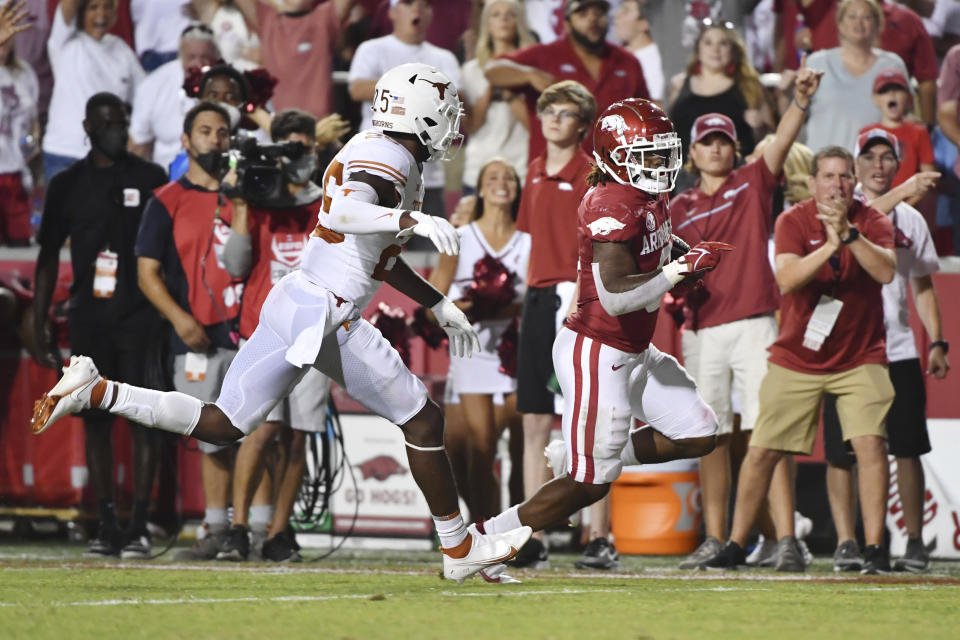 Arkansas running back AJ Green (0) slips past Texas defender B.J. Foster (25) to score a touchdown during the second half of an NCAA college football game Saturday, Sept. 11, 2021, in Fayetteville, Ark. (AP Photo/Michael Woods)