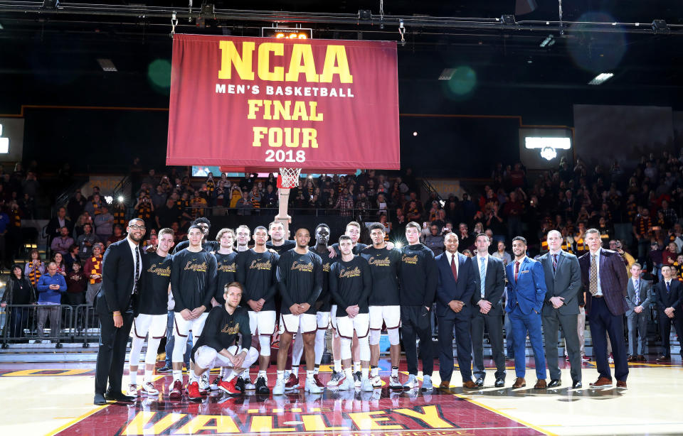 The Loyola Ramblers men's basketball team gathers for a group photograph in front of a Final Four banner during a pregame ceremony ahead of the 2018-19 season opener. (Getty)