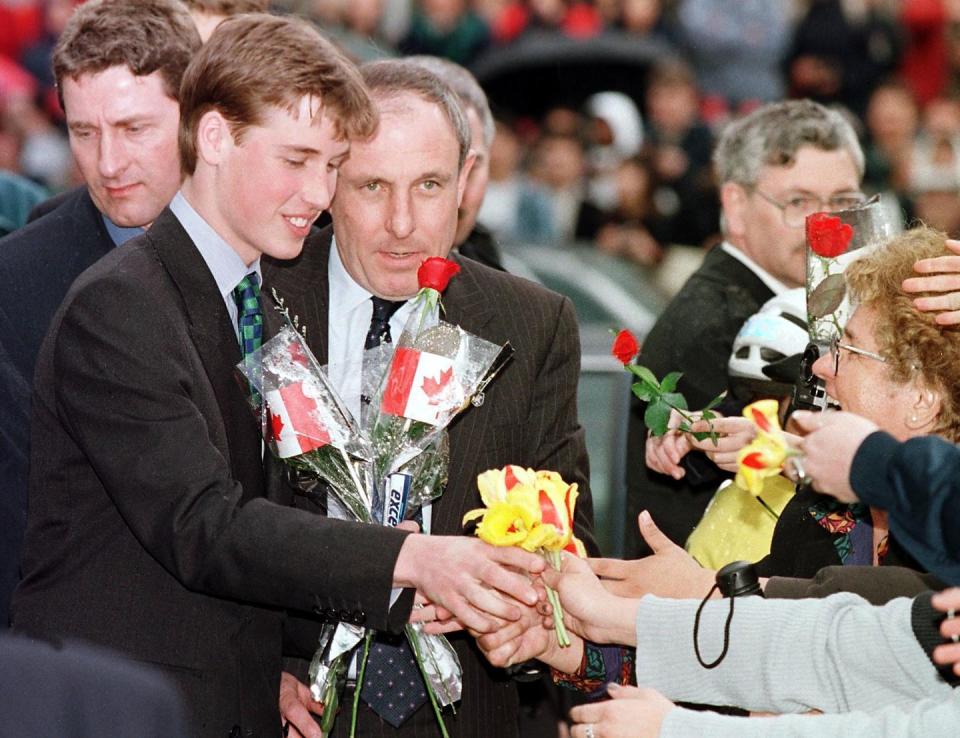 prince william recieves flowers from the crowd at