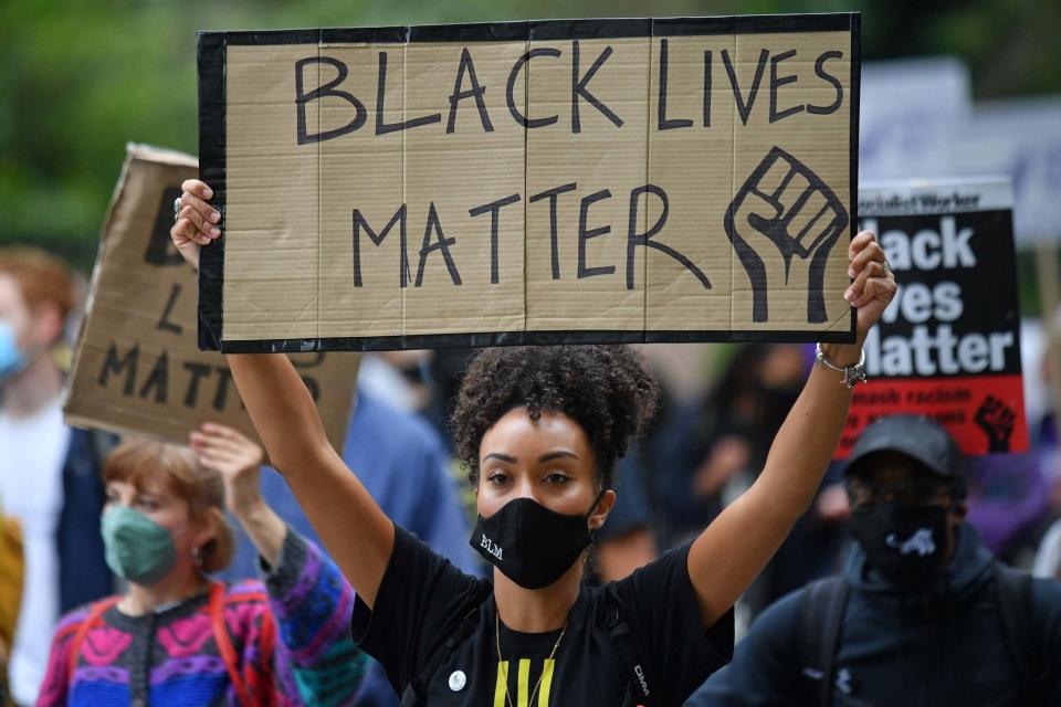 People held up placards as they marched through the streets of west London (AFP via Getty Images)