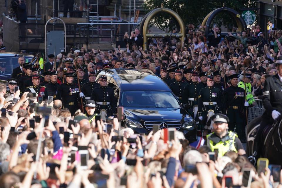 Members of the public held their phones high to capture images of the procession of Queen Elizabeth’s coffin to St Giles’ Cathedral, Edinburgh (Owen Humphreys/PA) (PA Wire)