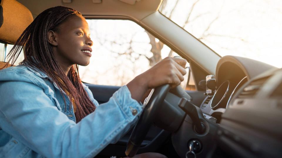 Young African woman driving a car.