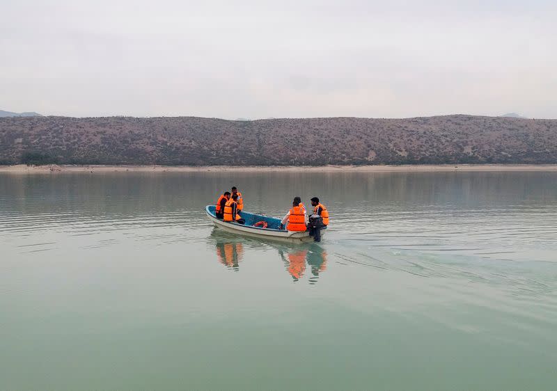 Rescue workers search for the victims, after a boat carrying religious school students capsized in Tanda lake in Kohat