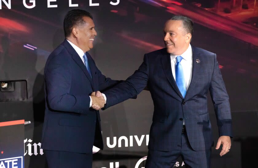 LOS ANGELES, CA - SEPTEMBER 21: Former Long Beach Police Chief Robert Luna, left, and Los Angeles County Sheriff Alex Villanueva share a handshake following their debate for County Sheriff on Wednesday, Sept. 21, 2022 at the Skirball Cultural Center in Los Angeles, CA. (Myung J. Chun / Los Angeles Times)