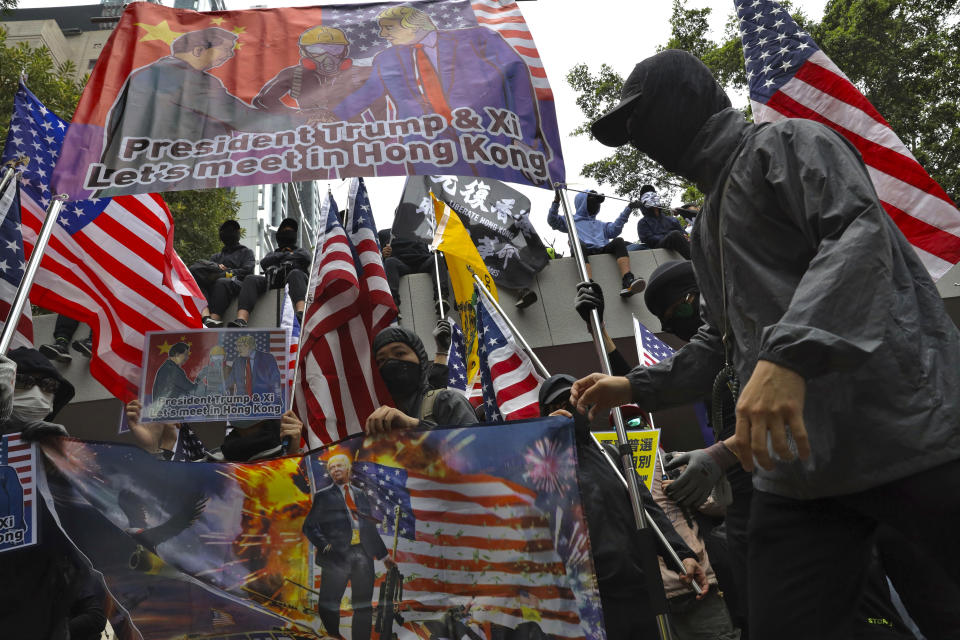 Participants wave U.S. flags and posters depicting President Donald Trump during a rally demanding electoral democracy and call for boycott of the Chinese Communist Party and all businesses seen to support it in Hong Kong, Sunday, Jan. 19, 2020. Hong Kong has been wracked by often violent anti-government protests since June, although they have diminished considerably in scale following a landslide win by opposition candidates in races for district councilors late last year. (AP Photo/Ng Han Guan)