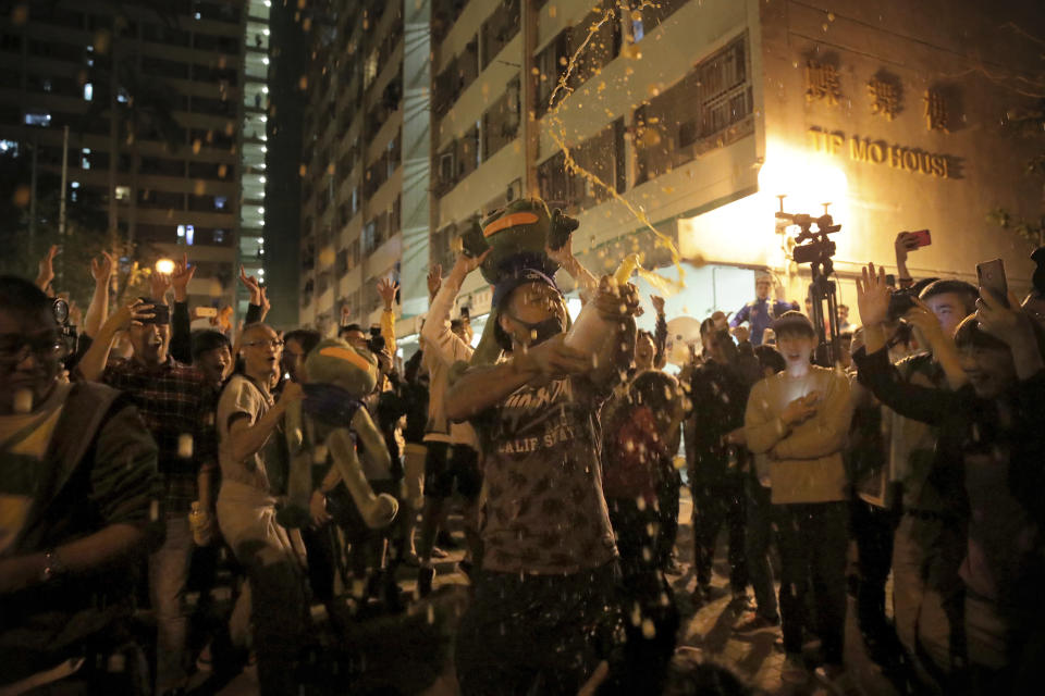 Pro-democracy supporters celebrate after pro-Beijing politician Junius Ho lost his election in Hong Kong, early Monday, Nov. 25, 2019. Vote counting was underway in Hong Kong early Monday after a massive turnout in district council elections seen as a barometer of public support for pro-democracy protests that have rocked the semi-autonomous Chinese territory for more than five months. (AP Photo/Kin Cheung)