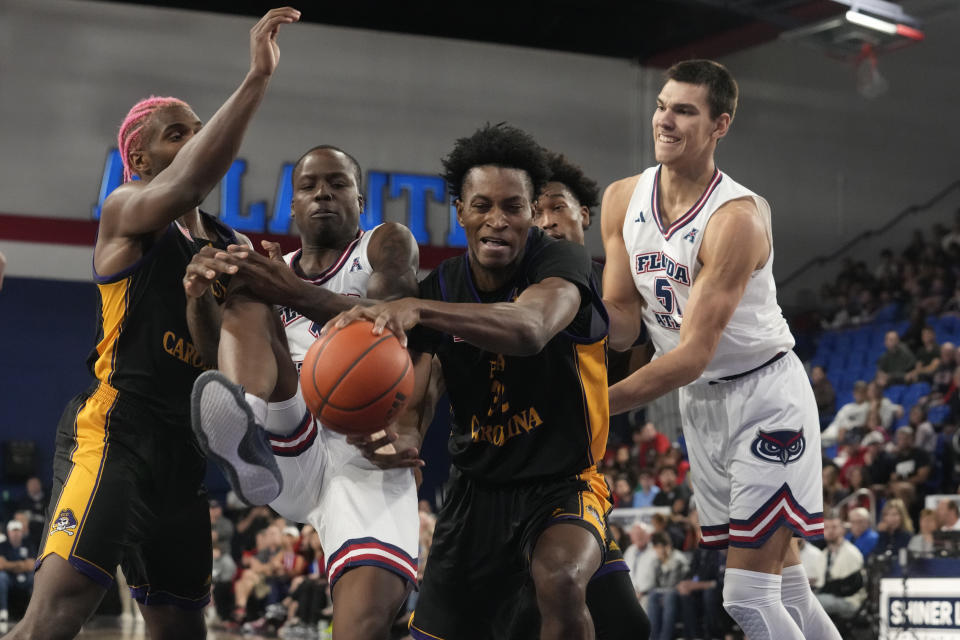 East Carolina center Cyr Malonga (32) grabs a rebound from Florida Atlantic guard Johnell Davis (1) during the first half of an NCAA college basketball game, Tuesday, Jan. 2, 2024, in Boca Raton, Fla. (AP Photo/Marta Lavandier)