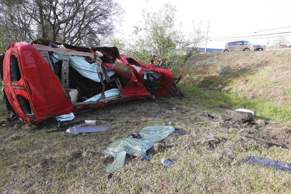 Motorists pass by a destroyed SUV that was thrown into a ditch along South Gloster near Eason Blvd Saturday, April 1, 2023 in Tupelo, Miss. Storms that dropped possibly dozens of tornadoes killed multiple people in small towns and big cities across the South and Midwest, tearing a path through the Arkansas capital, collapsing the roof of a packed concert venue in Illinois, and stunning people throughout the region Saturday with the damage's scope.(Thomas Wells/The Northeast Mississippi Daily Journal via AP)