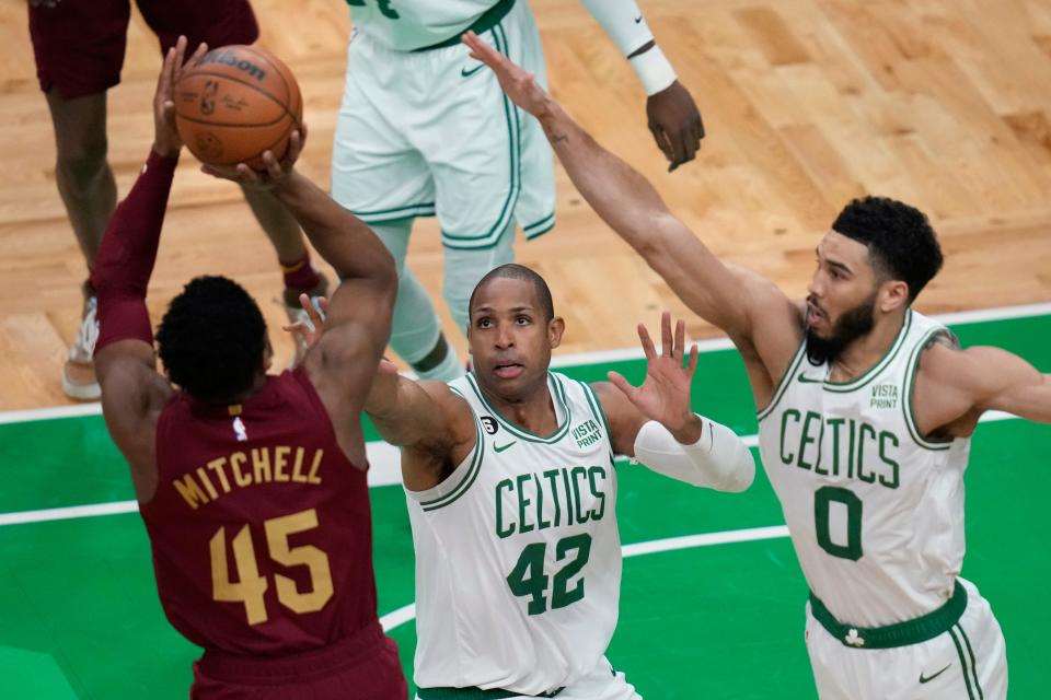 Boston Celtics center Al Horford (42) and forward Jayson Tatum (0) defend as Cleveland Cavaliers guard Donovan Mitchell (45) shoots during the first half of an NBA basketball game Wednesday, March 1, 2023, in Boston. (AP Photo/Charles Krupa)
