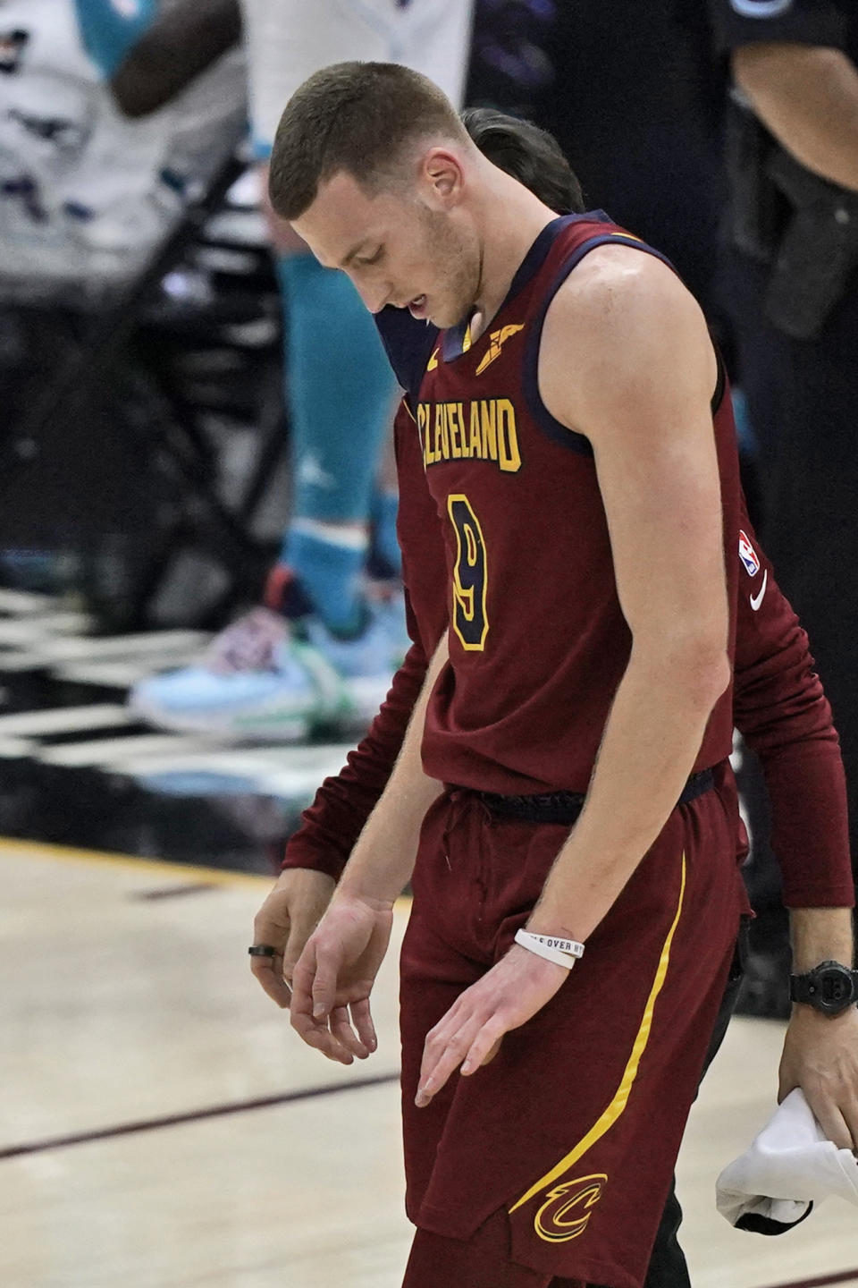 Cleveland Cavaliers' Dylan Windler looks down at his hand as he walks off the court after breaking his left hand in the season opener in the second half of an NBA basketball game against the Charlotte Hornets, Wednesday, Dec. 23, 2020, in Cleveland. The team said Thursday that Windler suffered a fourth metacarpal fracture when he took a hard fall in the third quarter against Charlotte. X-rays after the game were negative, but further tests revealed the fracture. (AP Photo/Tony Dejak)