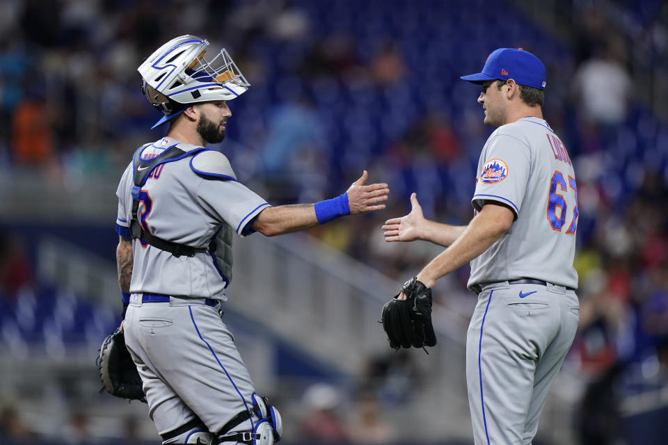 New York Mets relief pitcher Seth Lugo (67) and catcher Tomas Nido (3) congratulate each other after the Mets beat the Miami Marlins 4-0 during a baseball game, Saturday, July 30, 2022, in Miami. (AP Photo/Wilfredo Lee)