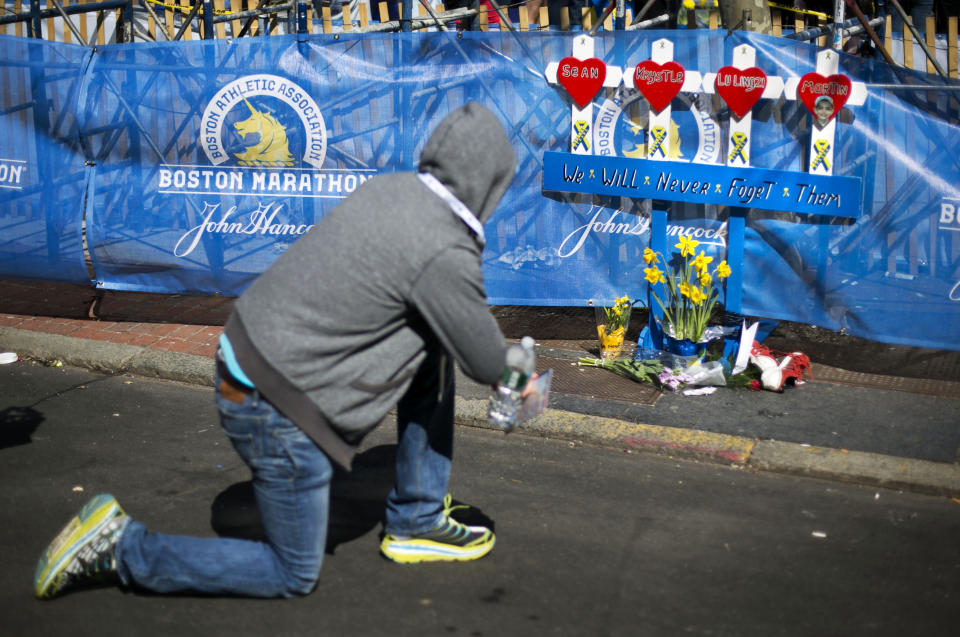 A man pauses at a memorial honoring the victims of the 2013 Boston Marathon bombings, Sunday, April 20, 2014, in Boston. The memorial is where the first explosion happened last year near the finish line. (AP Photo/Robert F. Bukaty)