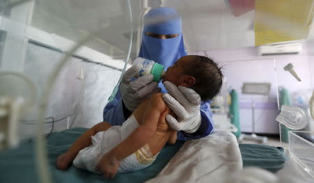 A nurse feeds a newborn baby in a special care unit at a hospital in Sanaa, Yemen July 30, 2015. REUTERS/Khaled Abdullah