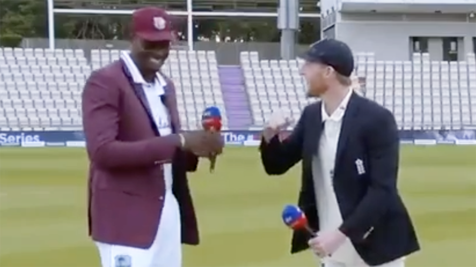 West Indies captain Jason Holder and England's Ben Stokes are pictured laughing after accidentally touching hands.