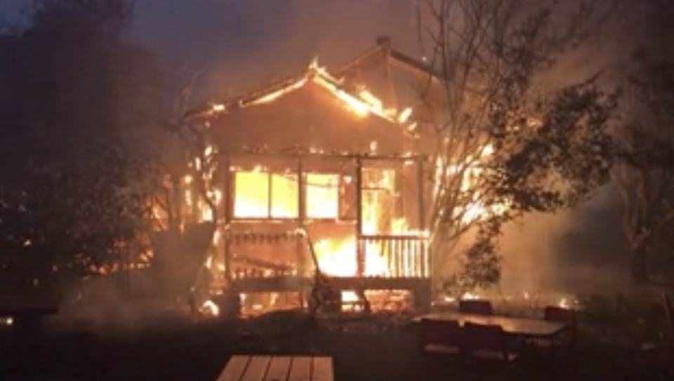 Flames engulf a house during the Gospers Mountain bushfire in Bilpin.