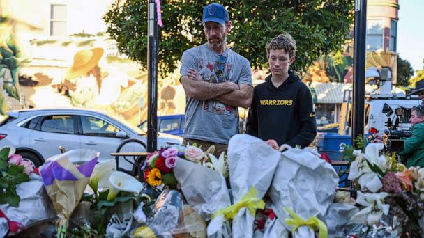 PHOTO: Matt Jones and his son Ryder Jones pay their respects at a makeshift memorial for those killed during a shooting in Half Moon Bay, Calif., Jan. 25, 2023. (Samantha Laurey/AFP via Getty Images)