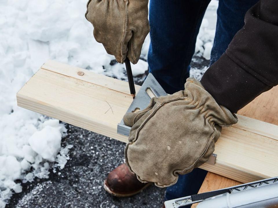 a person holding a pencil in winter gloves