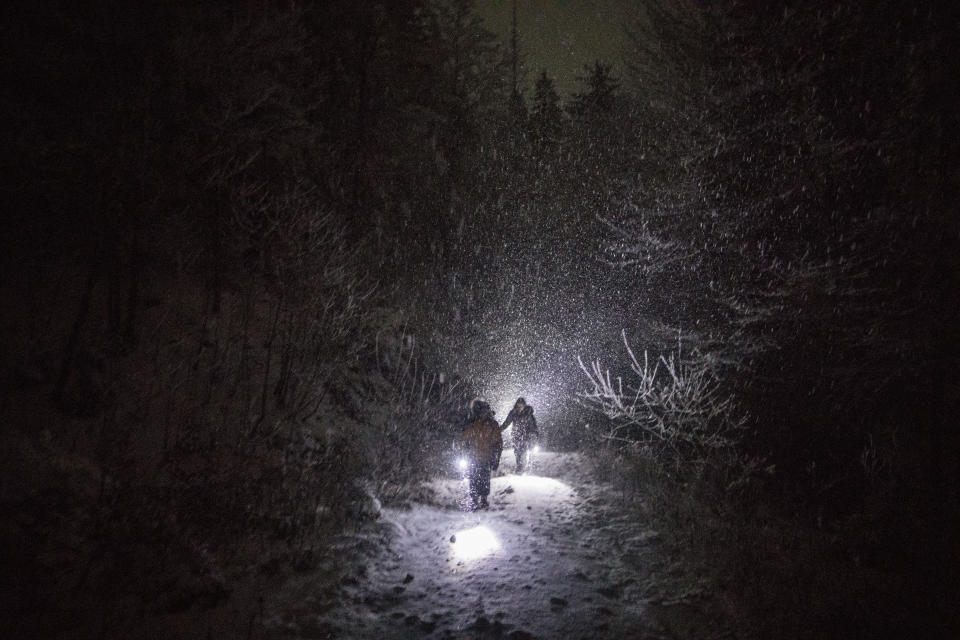 In this picture taken Thursday Dec. 12, 2019, a group of Syrian refugees walk their way under a blizzard as they attempt to enter the EU through Croatia in the mountains surrounding the town of Bihac, northwestern Bosnia. (AP Photo/Manu Brabo)
