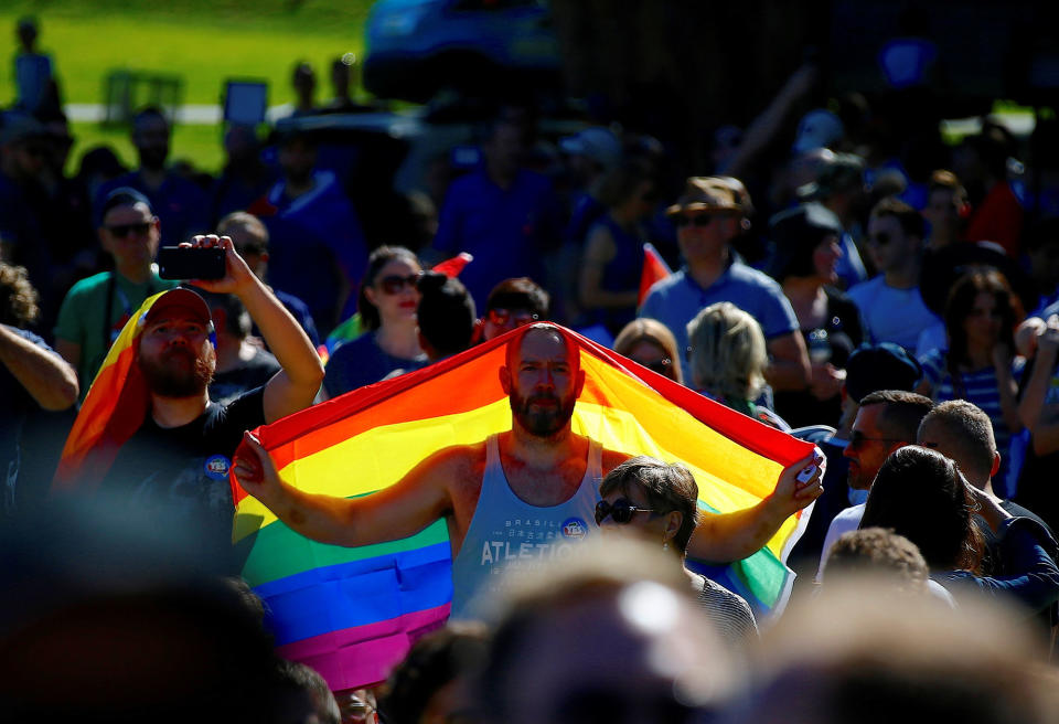 <p>A supporter of the ‘Yes’ vote holds a colorful flag as he celebrates after it was announced the majority of Australians support same-sex marriage in a national survey, paving the way for legislation to make the country the 26th nation to formalize the unions by the end of the year, at a rally in central Sydney, Australia, Nov. 15, 2017. (Photo: David Gray/Reuters) </p>