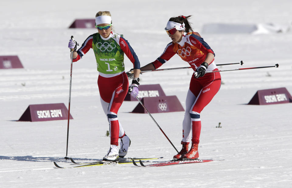 Norway's Heidi Weng, right, changes to Norway's Therese Johaug during the women's 4x5K cross-country relay at the 2014 Winter Olympics, Saturday, Feb. 15, 2014, in Krasnaya Polyana, Russia. (AP Photo/Matthias Schrader)