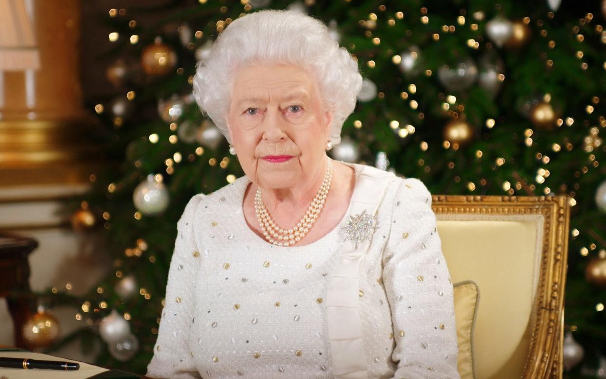 The Queen delivers her Christmas message at a desk in the 1844 Room at Buckingham Palace - PA