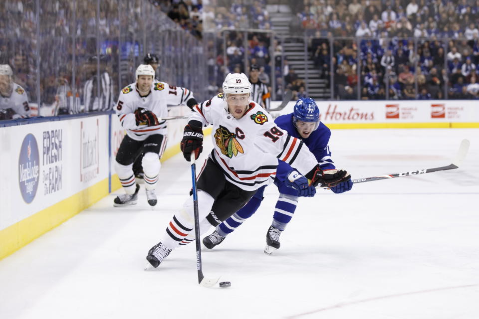 Chicago Blackhawks centre Jonathan Toews (19) skates with the puck as Toronto Maple Leafs centre Adam Brooks trails during first period NHL hockey action in Toronto, Saturday, Jan. 18, 2020. (Cole Burston/The Canadian Press via AP)