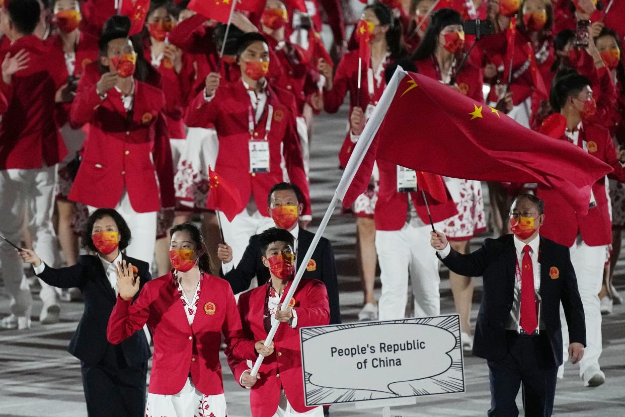 Zhu Ting and Zhao Shuai, of China, carry their country's flag during the opening ceremony in the Olympic Stadium at the 2020 Summer Olympics, Friday, July 23, 2021, in Tokyo, Japan. 