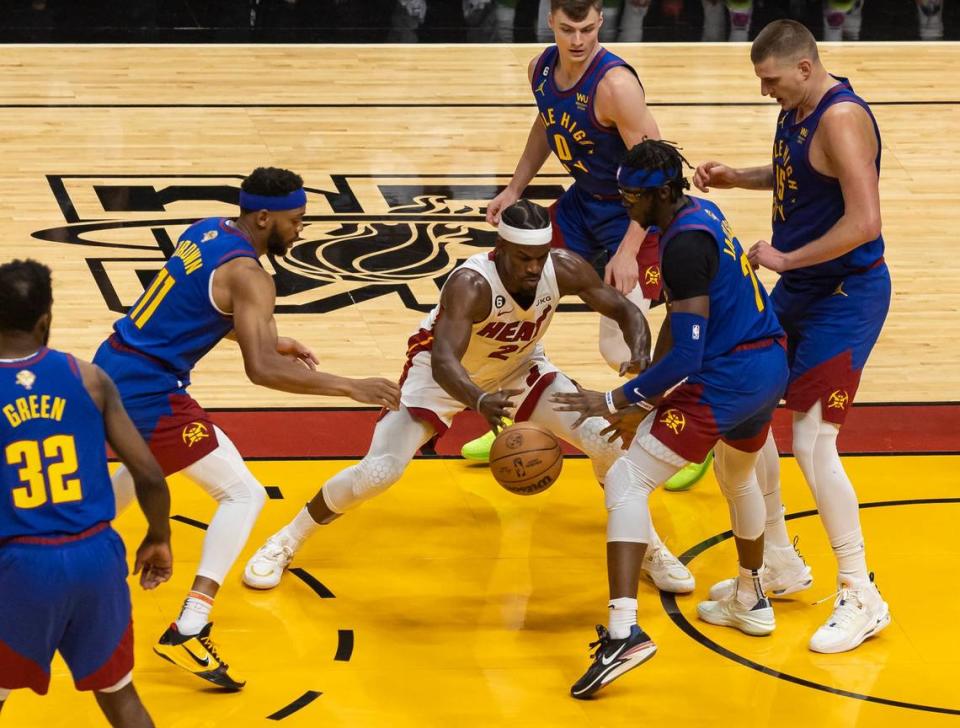 El jugador del Heat Jimmy Butler (centro) trata de pasar la defensa de los Nuggets de Denver, en el tercer partido de las Finales de la NBA, celebrado el 7 de junio de 2023 en Miami.