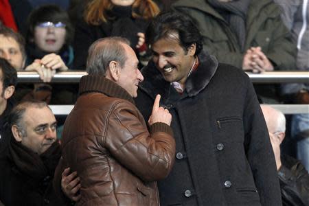 Paris St Germain's owner and Qatar's Crown Prince Sheikh Tamim Bin Hamad Al Thani (R) speaks with Paris Mayor Bertrand Delanoe during the French Ligue 1 soccer match against Montpellier at Parc des Princes stadium in Paris in this February 19, 2012 file photo. REUTERS/Benoit Tessier/Files