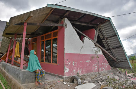 A villager sits at her damaged house after an earthquake hit Sembalun Bumbung village in Lombok Timur, Indonesia, July 29, 2018. Antara Foto/Ahmad Subaidi/via REUTERS