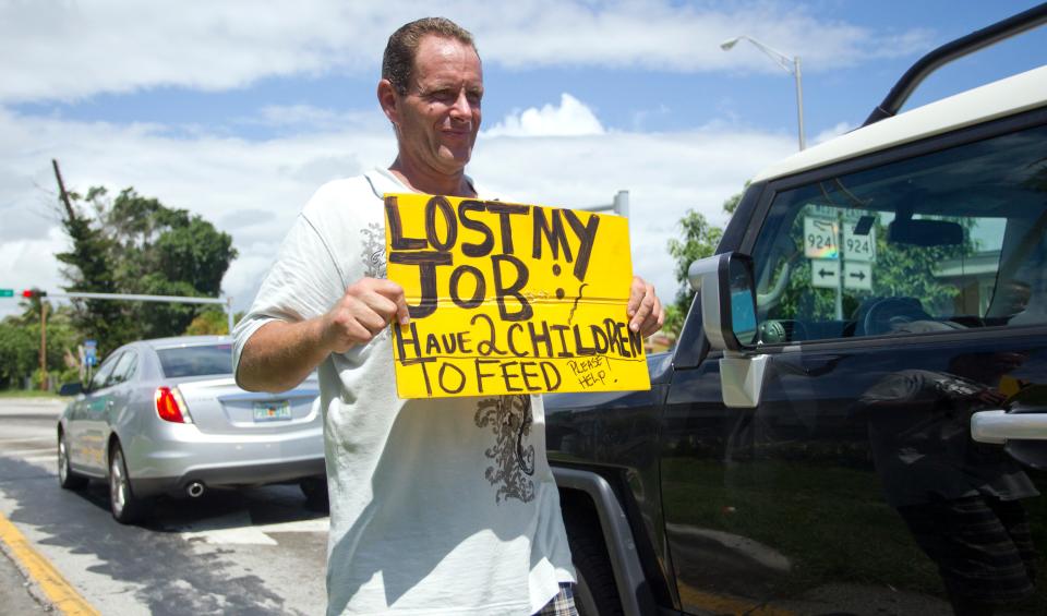 An unidentified man, who lost his job two months ago after being hurt on the job, works on a Miami street corner to collect money for his family on Sept. 16, 2010.
