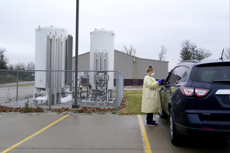 Registered nurse Brenna Smith administers a COVID-19 test to a drive-up patient outside Scotland County Hospital Tuesday, Nov. 24, 2020, in Memphis, Mo. Cases of coronavirus are on the rise in America stressing hospitals that serve rural areas like Scotland County. (AP Photo/Jeff Roberson)