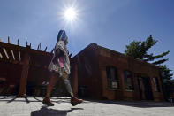 Claudine Humure, of Rwanda, takes a walk outside Next Step Bionics & Prosthetics, while testing her new prosthetic leg, Monday, Sept. 20, 2021, in Newton, Mass. Humure was orphaned during her country's genocide and lost part of her leg to childhood cancer. Her new prosthetic leg was provided free by the prosthetic clinic and features the latest in artificial limb technology. (AP Photo/Charles Krupa)