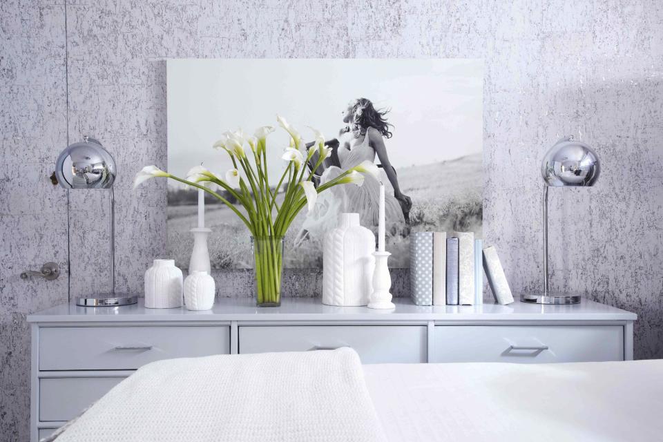 This publicity photo shows a guest bedroom by Designer Brian Patrick Flynn for HGTV.com with wintry appeal, where Flynn had a flea market dresser updated with a sprayed coat of blue-gray lacquer, then accessorized it with all white pieces. Flynn suggests mixing different shades of white along with blue-grays to achieve a well-balanced, wintry look indoors. (AP Photo/Brian Patrick Flynn for HGTV.com, Daniel J. Collopy)