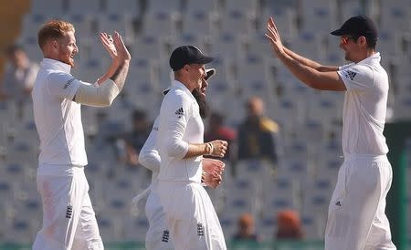 Cricket - India v England - Third Test cricket match - Punjab Cricket Association Stadium, Mohali, India - 28/11/16. England's Ben Stokes, Joe Root and Alastair Cook (L-R) celebrate the dismissal of India's Ravichandran Ashwin. REUTERS/Adnan Abidi