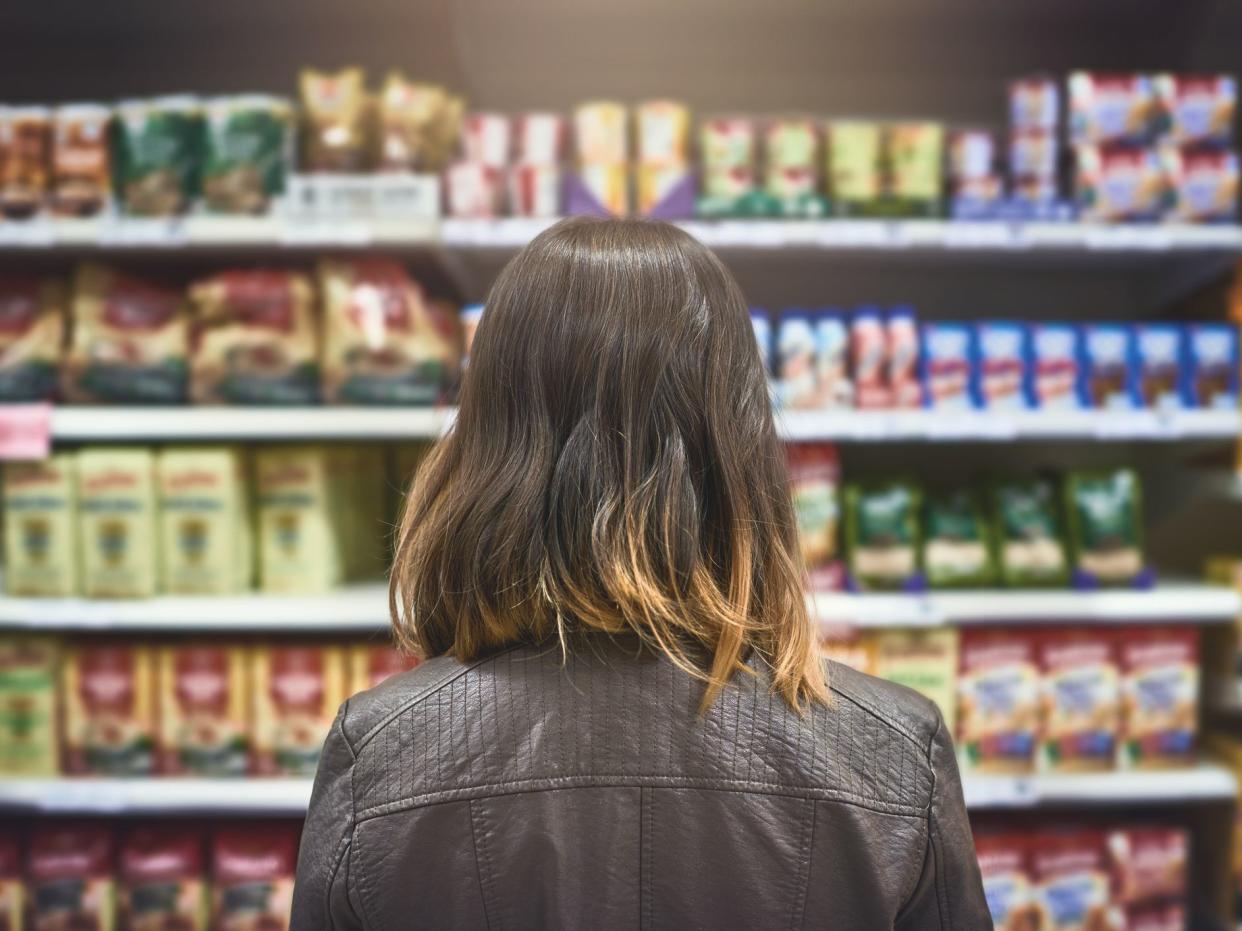 Rearview shot of a young woman shopping at a grocery store