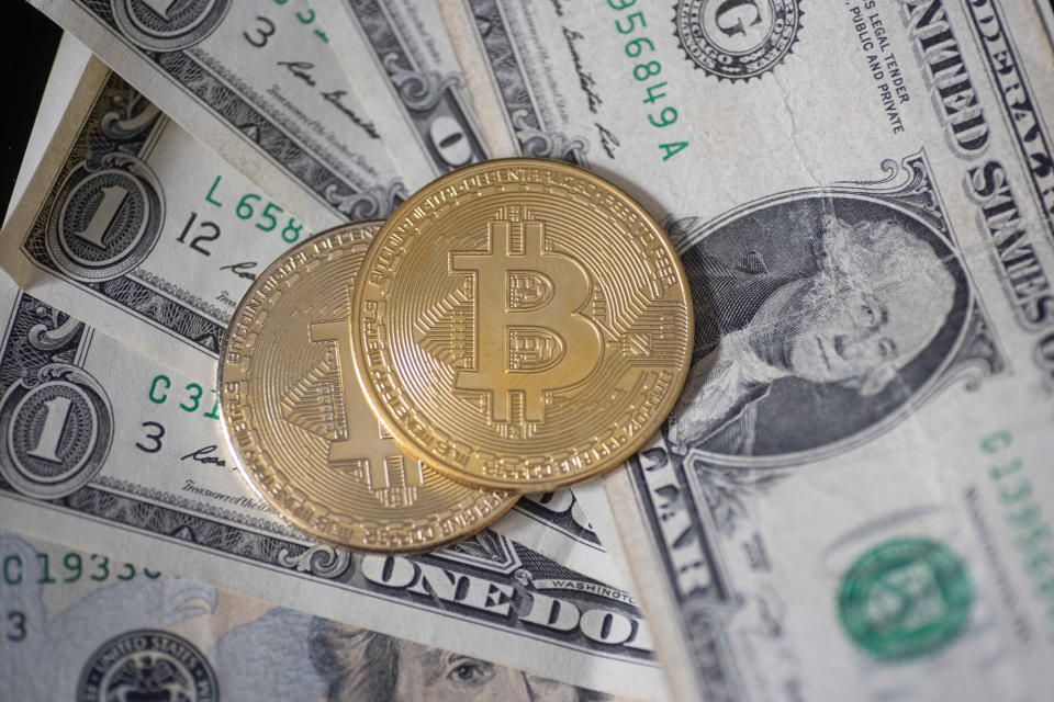 Bitcoin y billetes de dólar. (Foto: Nicolas Economou/NurPhoto via Getty Images)
