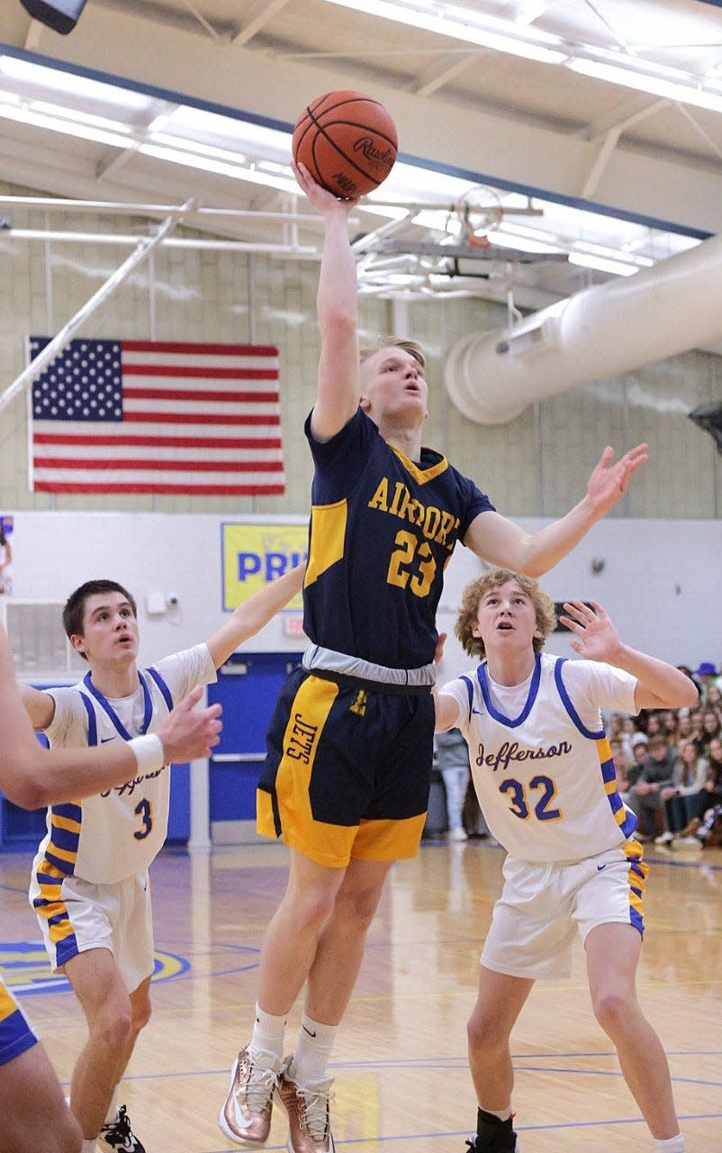 Airport's Tyler Lakatos goes up over Gabe Gelso (3) and Trey Oldenburg (32) of Jefferson Friday night. Lakatos scored all 6 of his points in the first quarter to lead the Jets to a 59-45 victory.