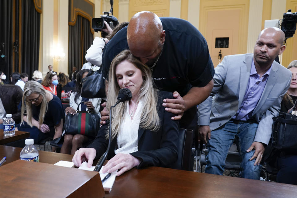 U.S. Capitol Police Sgt. Harry Dunn talks to U.S. Capitol Police officer Caroline Edwards after she testified during a public hearing of the House select committee investigating the attack is held on Capitol Hill, Thursday, June 9, 2022, in Washington. U.S. Capitol Police Sgt. Aquilino Gonell looks on at right. (AP Photo/Andrew Harnik)