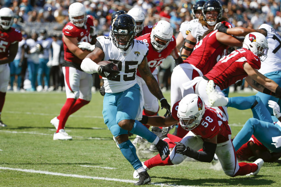 Jacksonville Jaguars running back James Robinson (25) slips past Arizona Cardinals middle linebacker Jordan Hicks (58) for a touchdown on a 4-yard run during the second half of an NFL football game, Sunday, Sept. 26, 2021, in Jacksonville, Fla. (AP Photo/Stephen B. Morton)