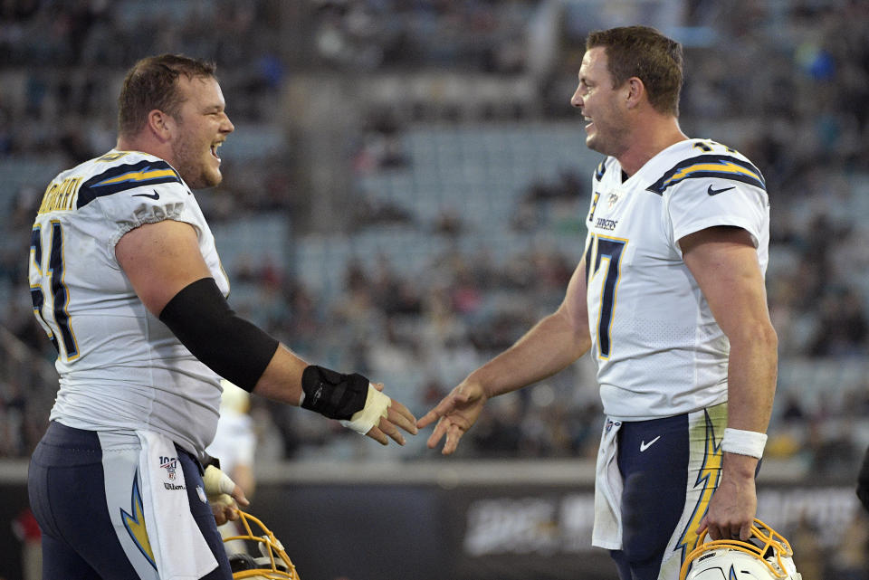 Los Angeles Chargers quarterback Philip Rivers, right, and center Scott Quessenberry, left, celebrate after scoring a touchdown against the Jacksonville Jaguars during the second half of an NFL football game, Sunday, Dec. 8, 2019, in Jacksonville, Fla. (AP Photo/Phelan M. Ebenhack)