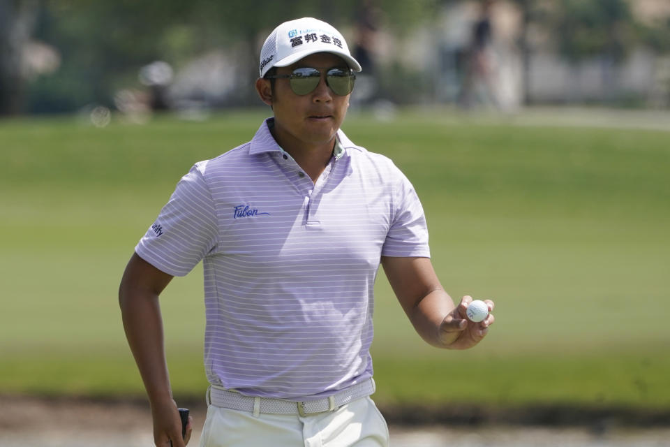 C.T. Pan of Taiwan shows his ball on the first hole during the final round of the Honda Classic golf tournament, Sunday, March 21, 2021, in Palm Beach Gardens, Fla. (AP Photo/Marta Lavandier)