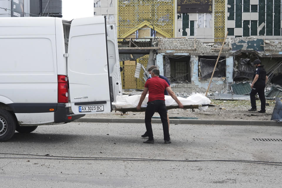 Rescuers load the body of a victim killed by Russian shelling in Kharkiv, Ukraine, Wednesday, July 20, 2022. (AP Photo/Andrii Marienko)