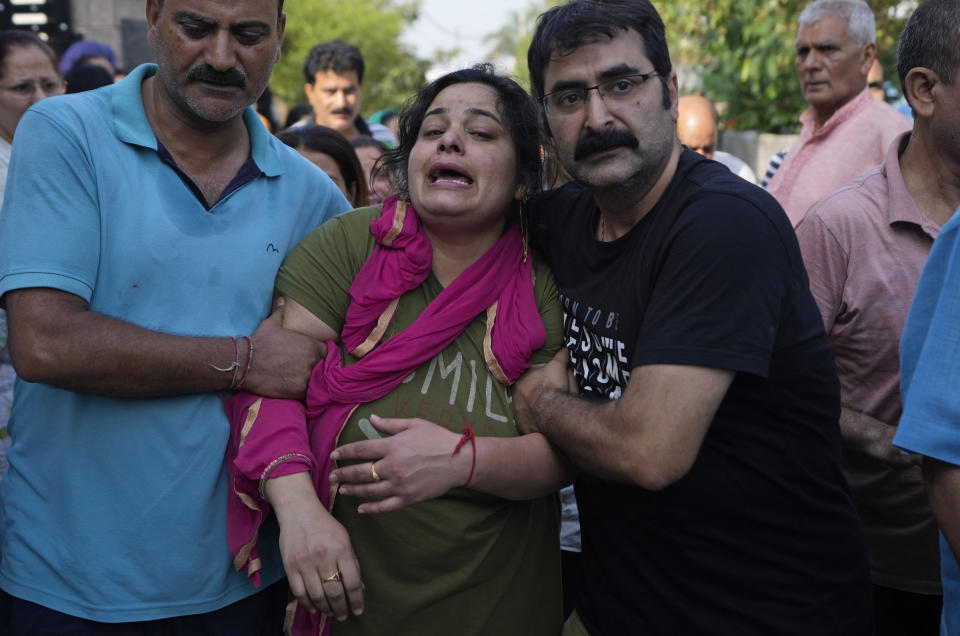 Meenakshi mourns during the cremation of her husaband Rahul Bhat, a government employee, killed on Thursday, in Jammu, India, Friday, May 13, 2022. Bhat, who was a minority Kashmiri Hindu known as "pandits," was killed by suspected rebels inside his office in Chadoora town in the Indian portion of Kashmir. (AP Photo/Channi Anand)