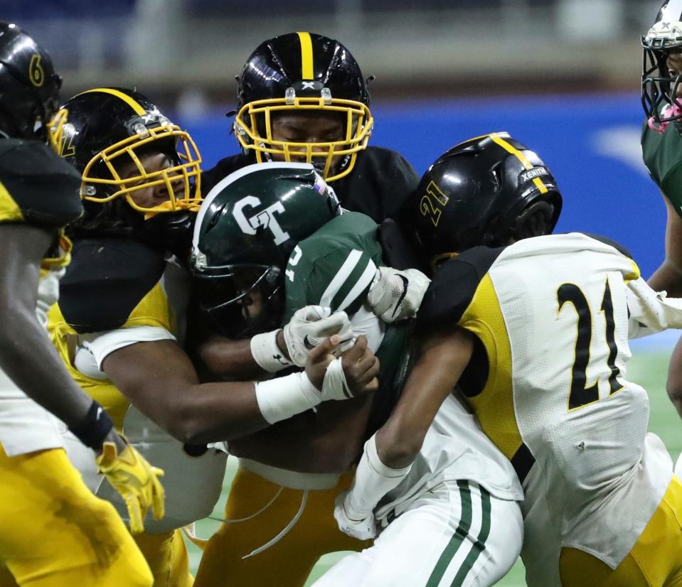 Detroit Cass Tech running back Will Sykes Jr is tackled by Detroit King defenders during first-half action at Ford Field in Detroit on Friday, Oct. 13, 2023.