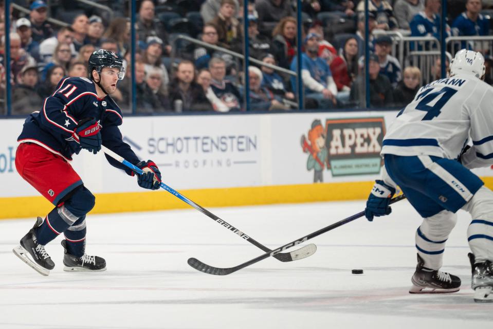 Dec 23, 2023; Columbus, Ohio, USA;
Columbus Blue Jackets center Adam Fantilli (11) passes the puck past Toronto Maple Leafs center Bobby McMann (74) during the third period of their game on Saturday, Dec. 23, 2023 at Nationwide Arena.